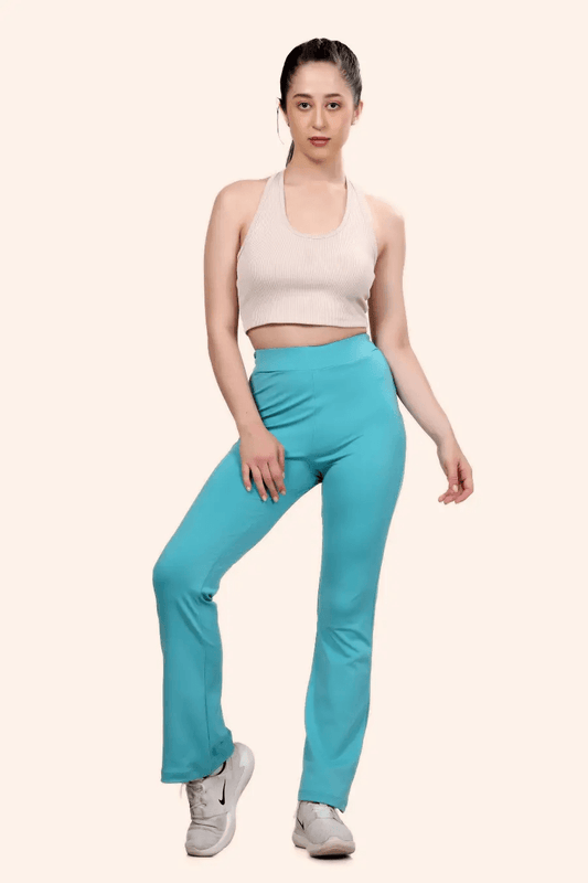 Model wearing high-waisted flared yoga pants in turquoise, designed for activewear and casual comfort. Sewing pattern available in multiple sizes.