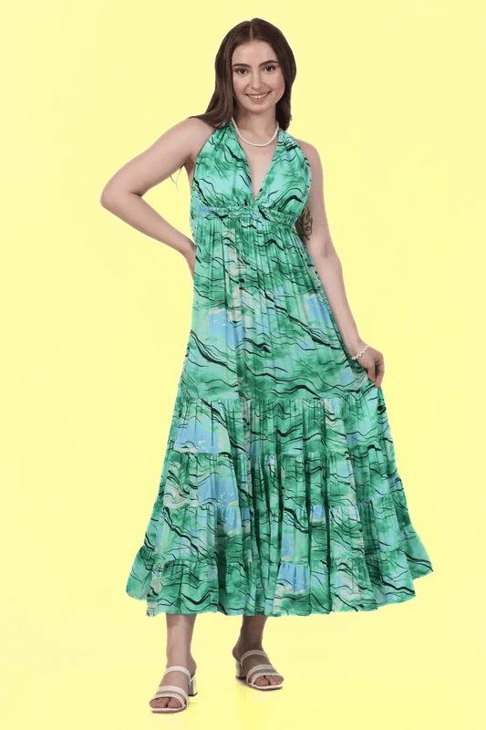 Model wearing a green halter neck maxi dress with a tiered skirt, made using Winslet's sewing pattern. Elegant and flowy design for various occasions.