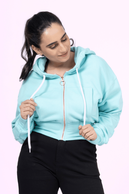Close-up of 'Rue' zip-up hoodie sewing pattern featuring gold zipper, drawstring hood, and ribbed waistband in a cropped fit for women.