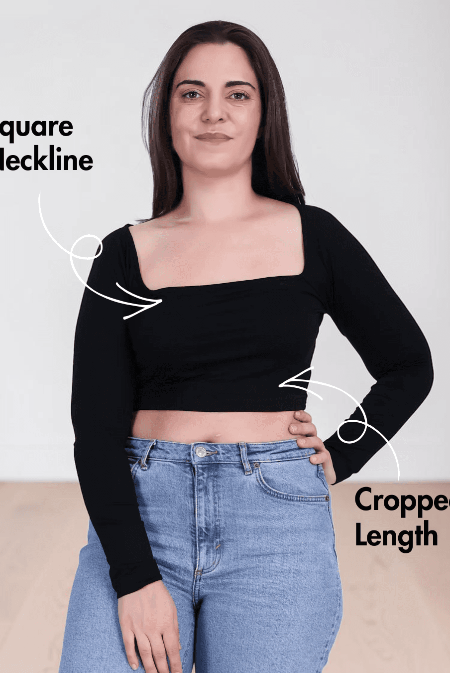 Woman wearing black square neck crop top with long sleeves and high-waisted jeans