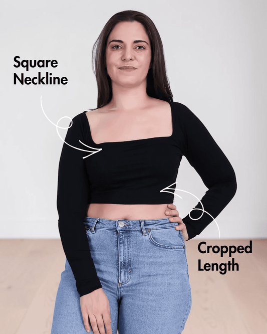 Woman wearing black square neck crop top with long sleeves and high-waisted jeans