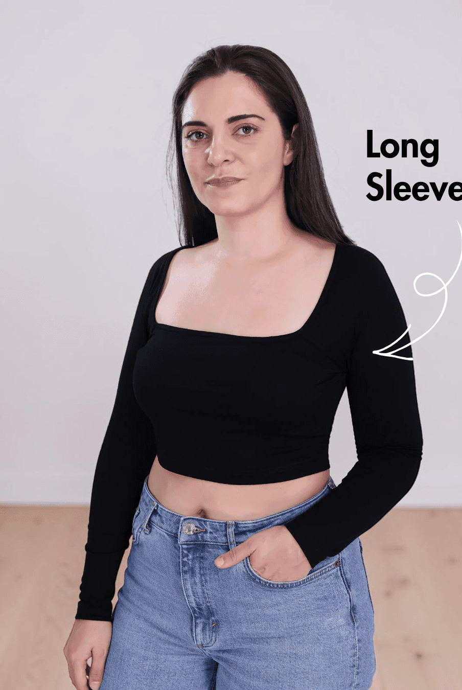 Side view of Woman wearing black square neck crop top with long sleeves and high-waisted jeans