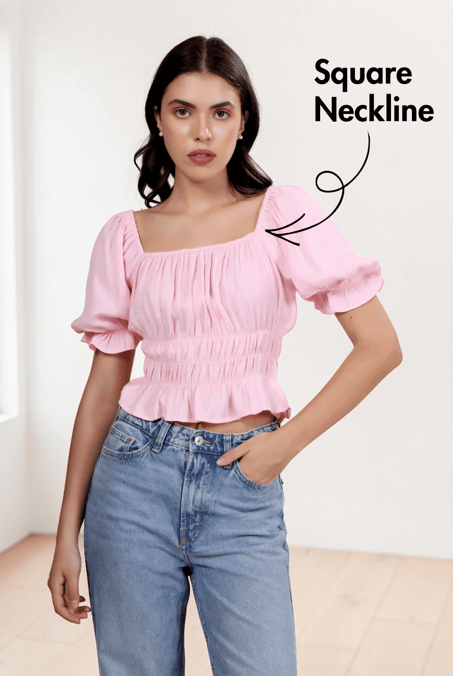 Model wearing pink puff sleeve top with square neckline and elastic shirring
