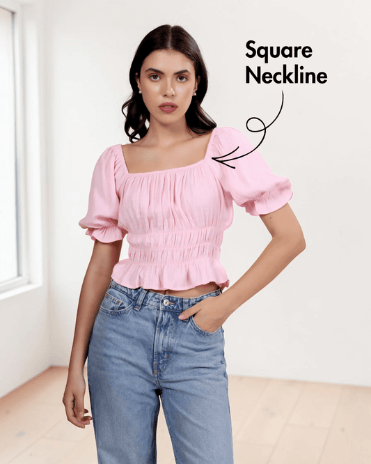 Model wearing pink puff sleeve top with square neckline and elastic shirring