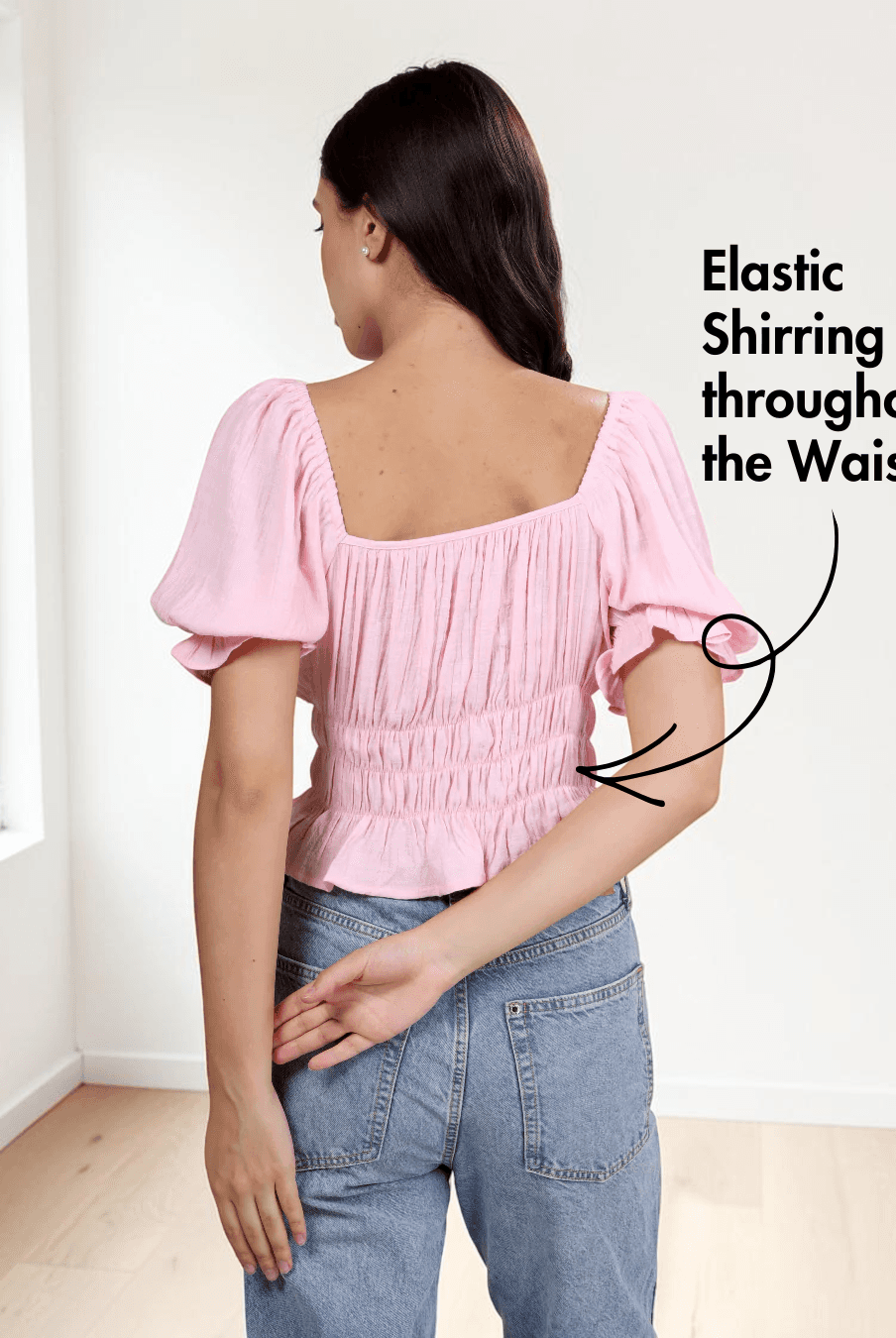 back view of pink cottagecore top with puff sleeves, ruched bodice, and flared hem