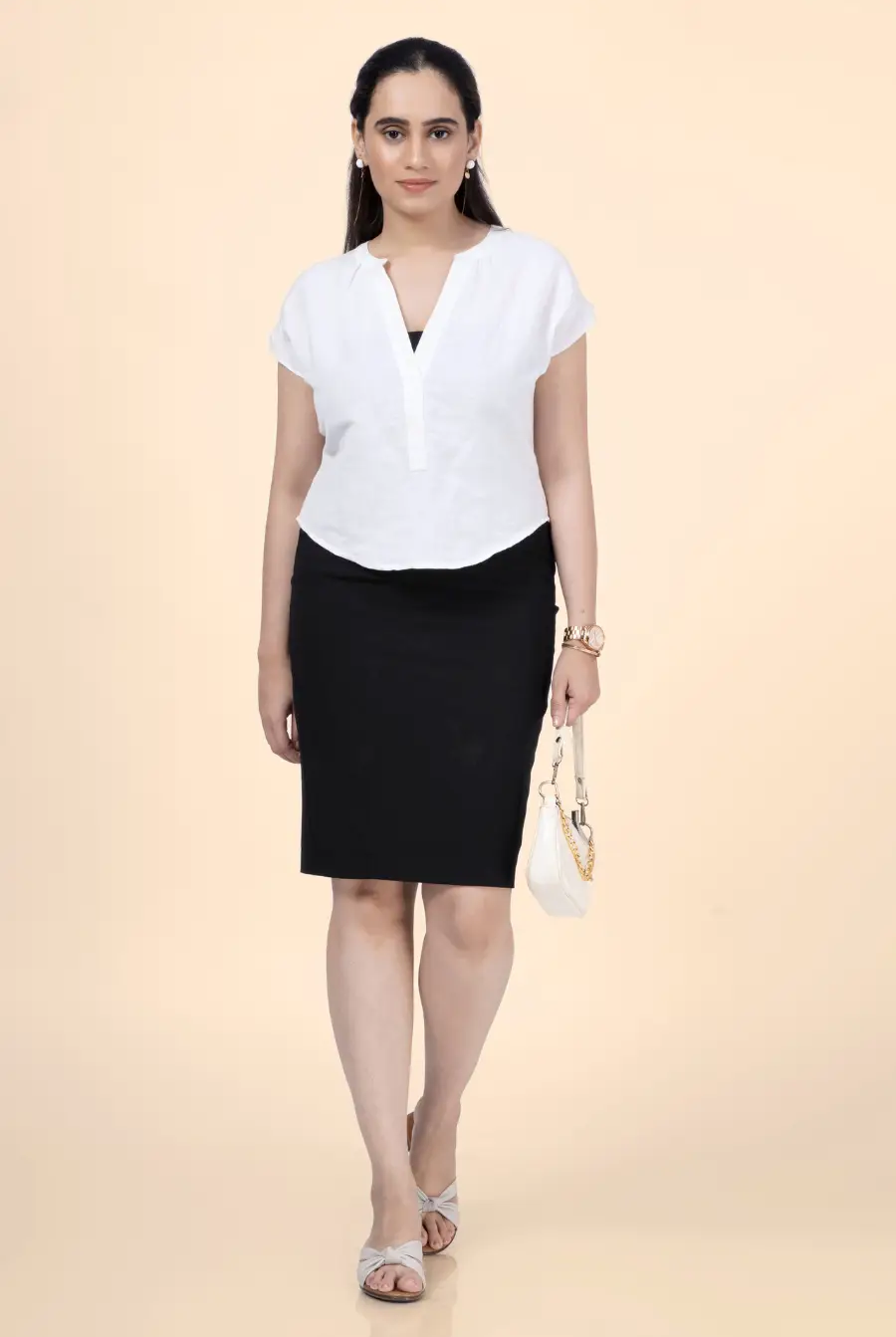 Model walking in a white short sleeve blouse made using the 'Bliss' sewing pattern, styled with a black skirt and accessories. A chic and easy-to-sew wardrobe staple.