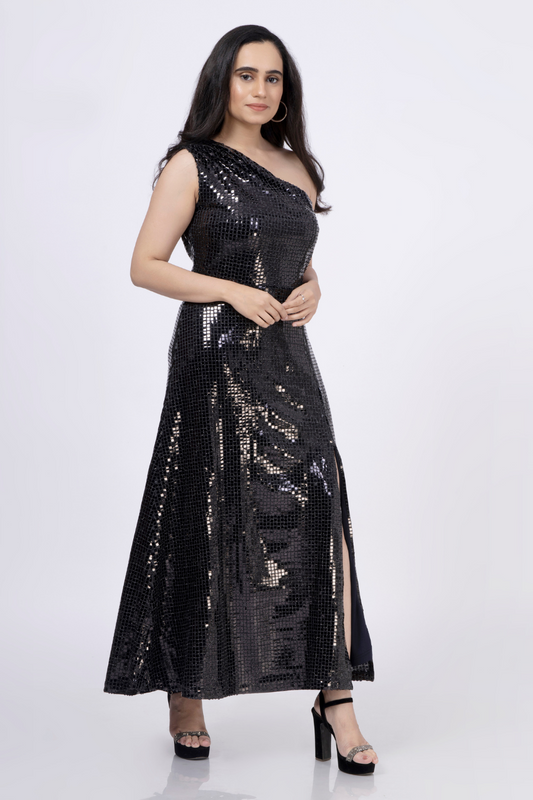 Model wearing a black sequined one-shoulder maxi dress with a thigh-high slit. DIY sewing pattern available in multiple sizes and formats.