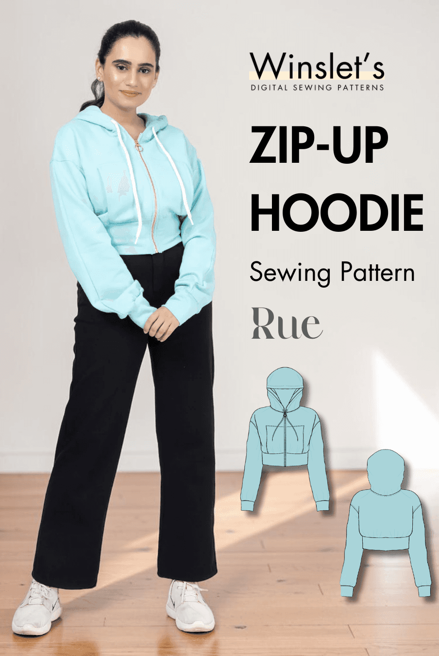 Women wearing light blue zip-up hoodie with drawstring hood, front zipper, and black pants, showcasing the sewing pattern for a cropped hoodie