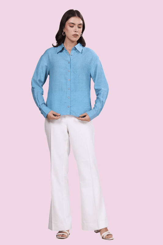 Model wearing a light blue oversized button-down shirt made using the 'Hayden' sewing pattern. Features a structured collar, long sleeves, and curved hem.