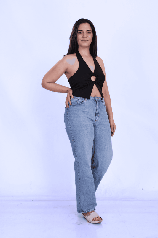 Model wearing black halter neck crop top with front cut-out and backless design, made from knit fabric, perfect for casual or party outfits.