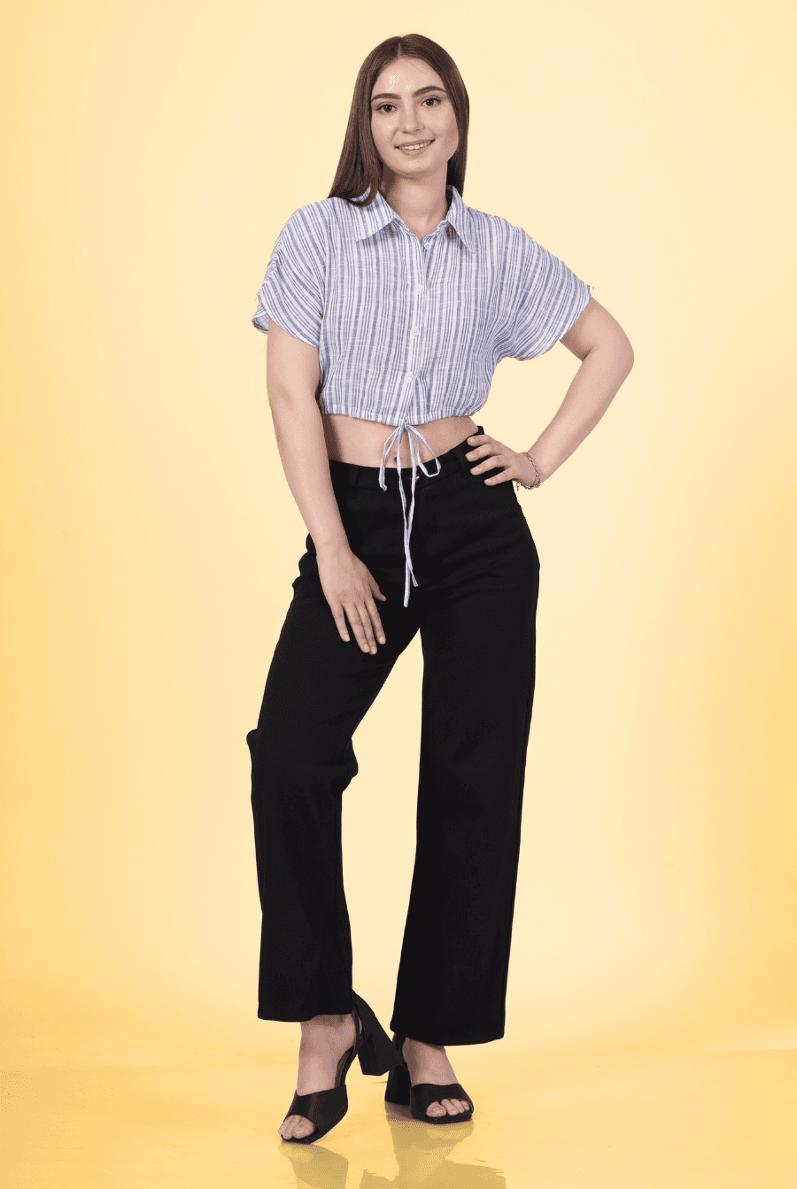 a woman posing for a picture in a striped shirt and black pants designed with winslets patterns