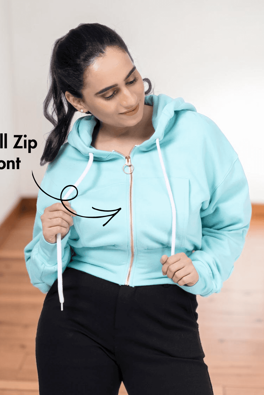Close-up of woman in light blue zip-up hoodie with full front zipper, highlighting the sewing pattern details for a women's crop jacket