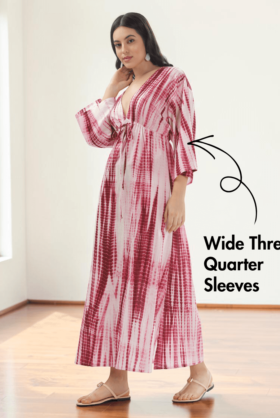 Model wearing pink and red tie-dye kaftan dress with deep V-neckline and wide three-quarter sleeves