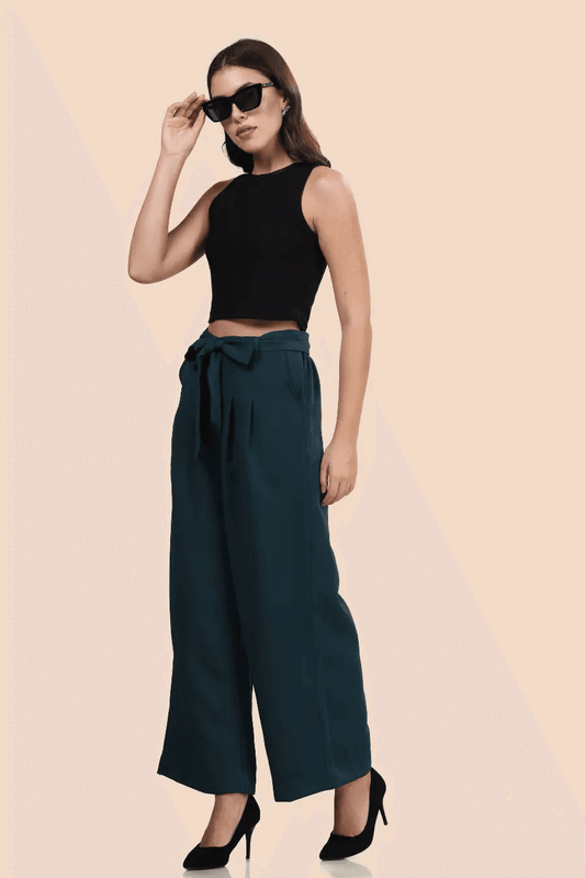Model wearing high-waisted wide-leg trousers with a belted waist in dark green. Stylish and comfortable design for casual and formal wear.