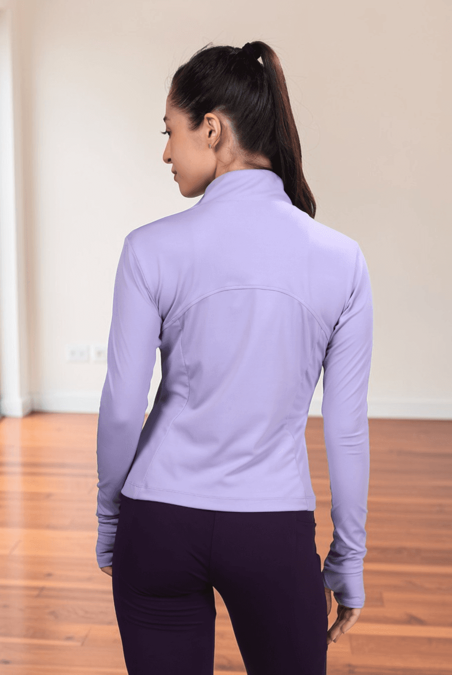 Women wearing lavender sports jacket with high collar and full zip