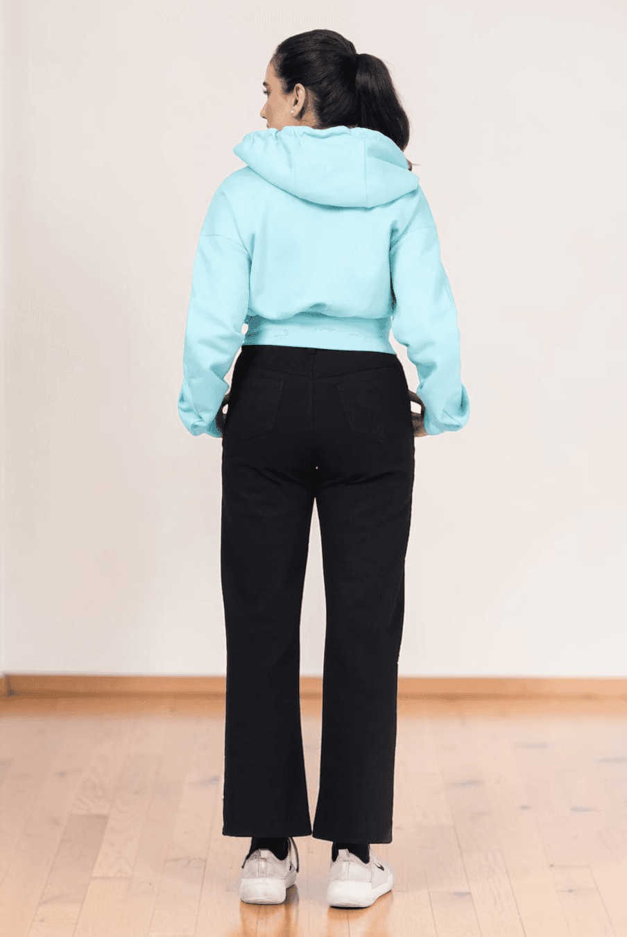 Back view of light blue cropped hoodie with hood and long sleeves