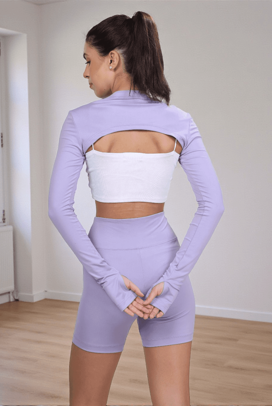 Back view of Sookie bolero shrug sewing pattern showing cropped silhouette and thumbhole sleeve detail for activewear or casual wear.