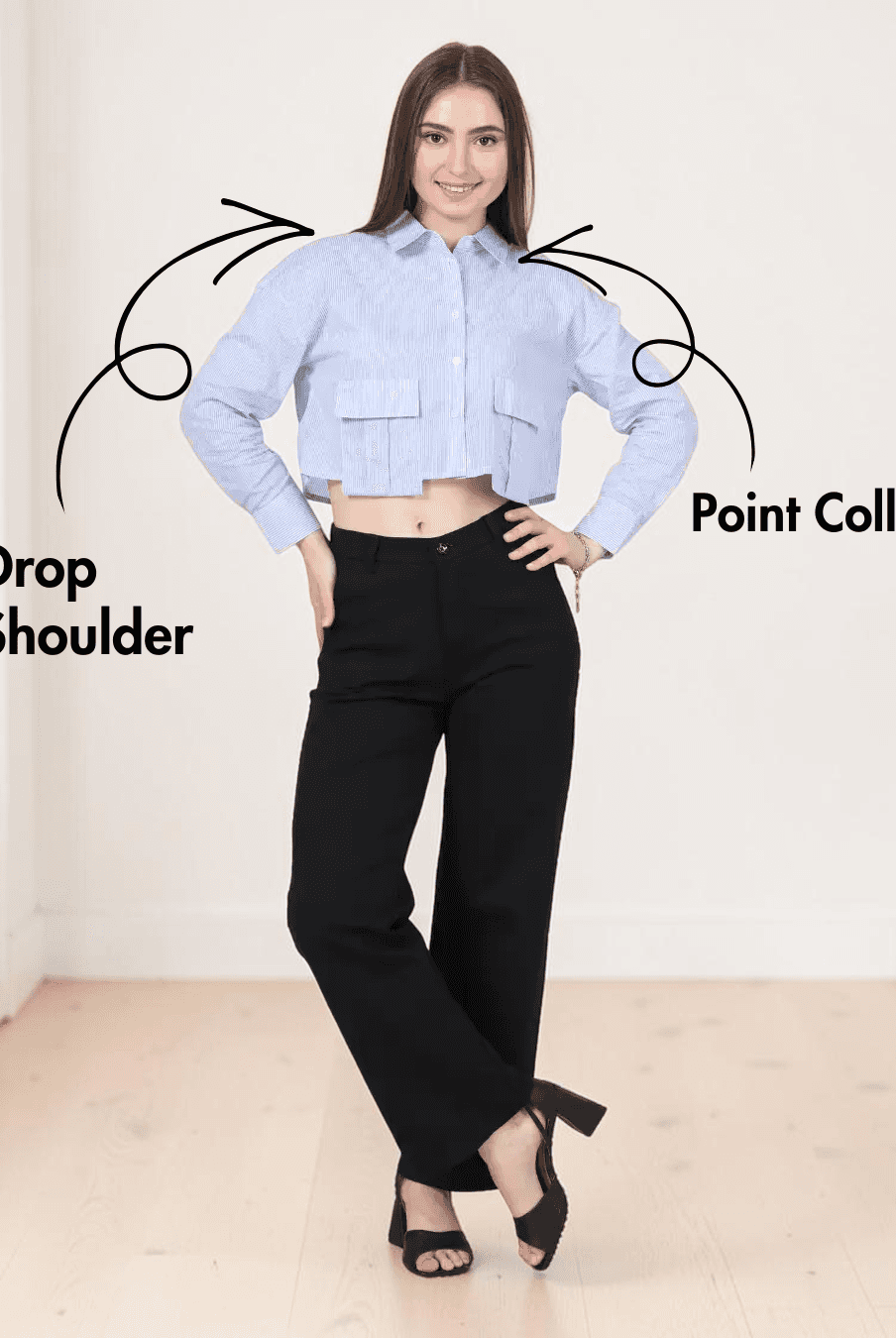 Model in cropped blue striped utility shirt with large bellows pockets, long sleeves, point collar, and black pants