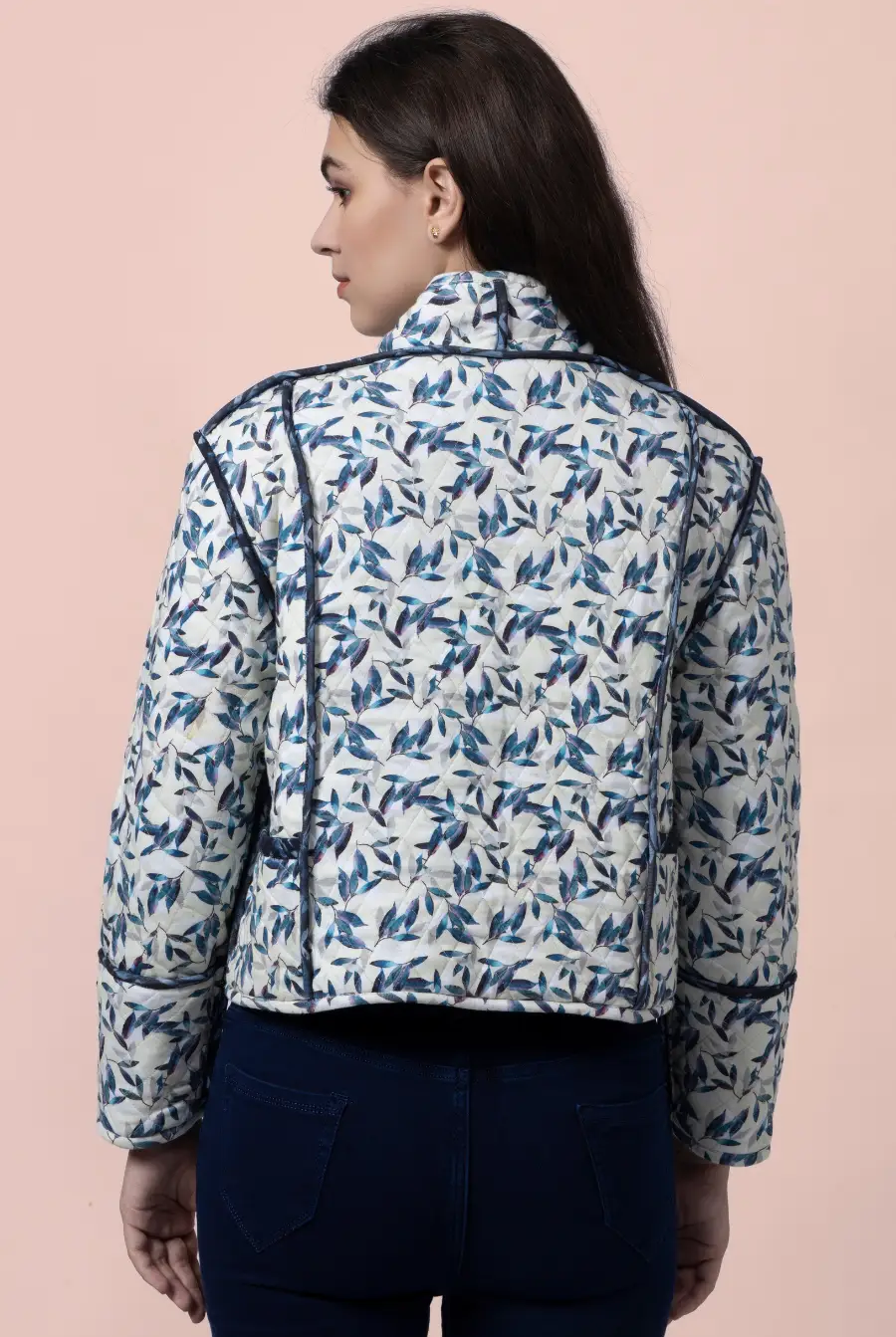 Back view of the Romy reversible quilted jacket in a blue and white leaf pattern. Features structured contrast binding for a stylish finish.