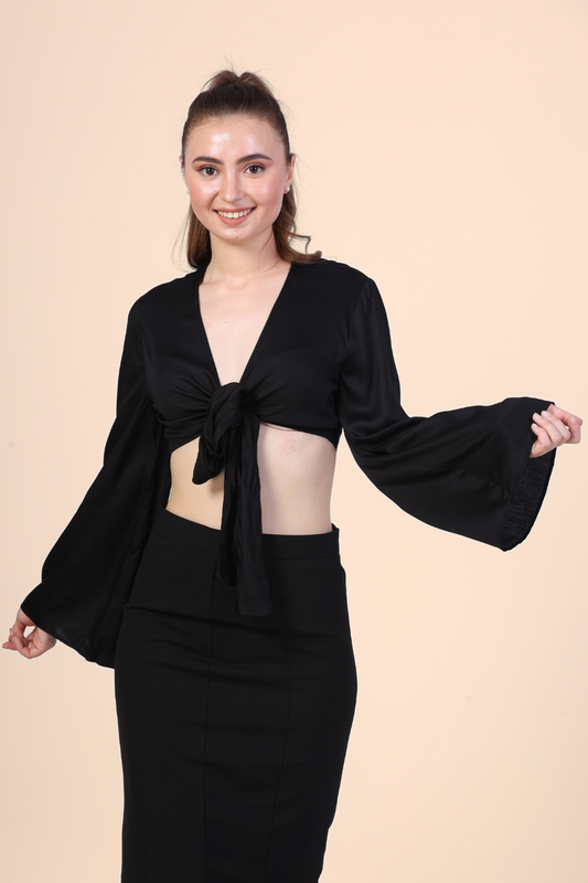 Image of a model wearing a tie front crop top sewed with winslet's patterns paired with black midi skirt