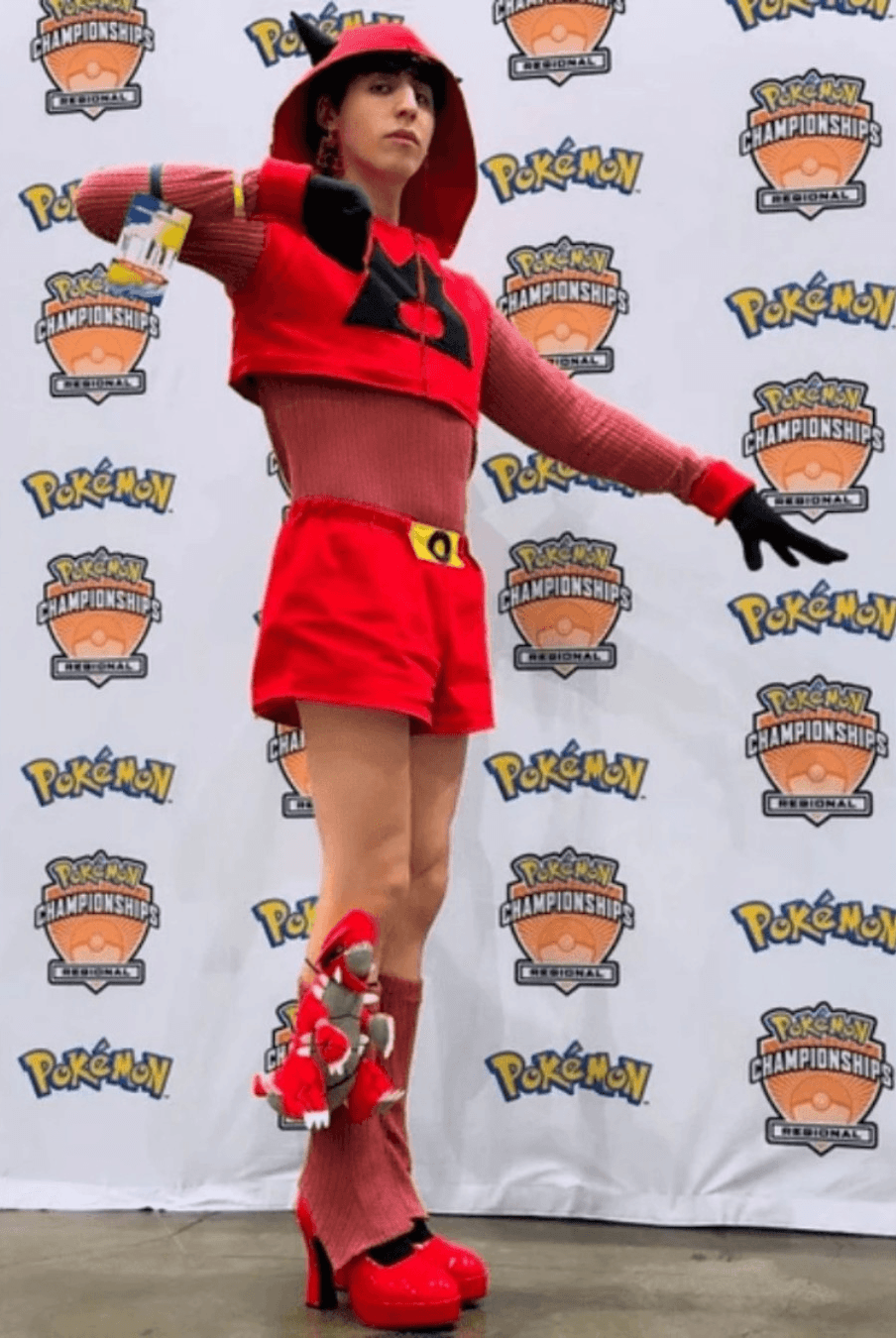 Person dressed in a red and black Pokémon-themed costume at a Pokémon Championships event