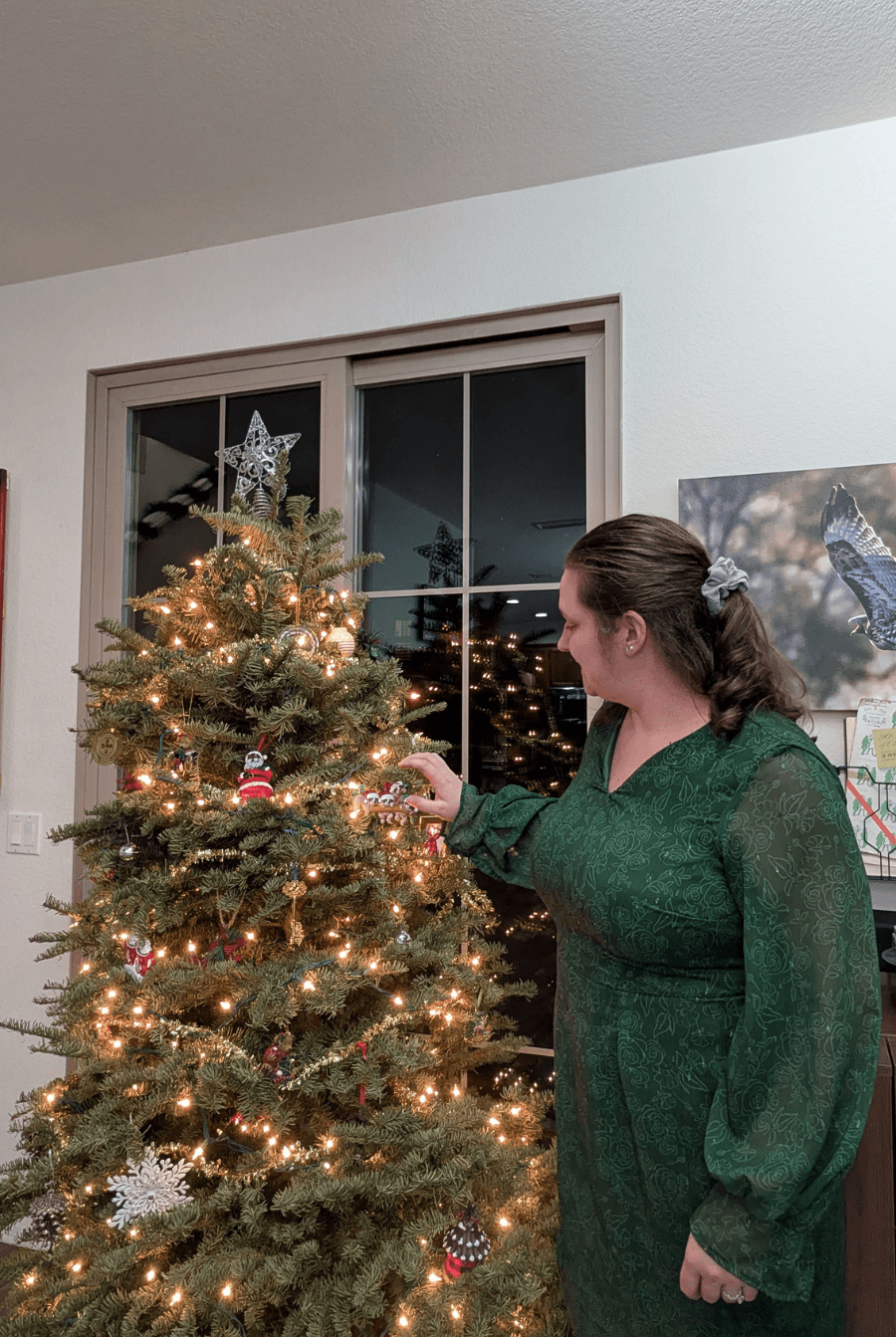 Green version of the 'Celestia' Keyhole Sheath Dress sewing pattern, worn during Christmas, featuring long sleeves and a fitted silhouette.