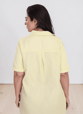 Yellowe linen shirt dress with traditional collar, button-down front, and side pockets, back view