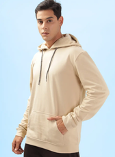Front view of a beige men's hoodie from the 'Atlas' sewing pattern. Displays a casual fit with ribbed cuffs, hem, and a spacious kangaroo pocket.