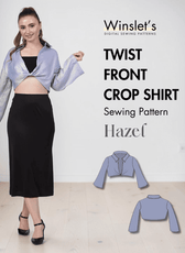 Model wearing blue twist front crop shirt with long bell sleeves and plunging neckline