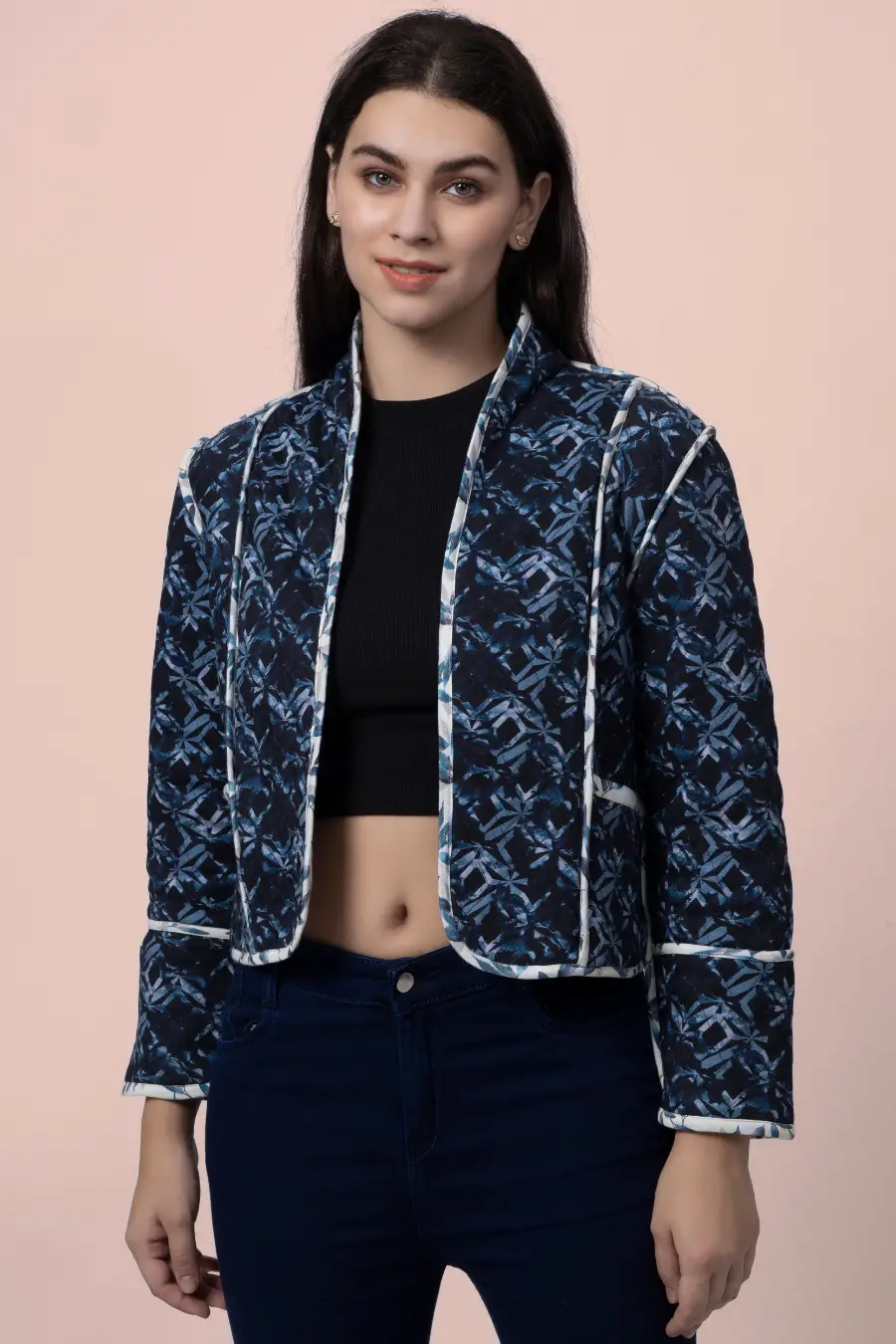 Close-up of the Romy reversible quilted jacket in a dark blue geometric pattern. Features contrast binding for a stylish and structured look.