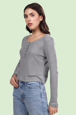 Side view of a model in a gray long sleeve Henley top from the Riley sewing pattern. Showcases the relaxed fit and buttoned neckline.