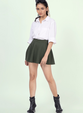 Front view of a model in a dark green skater skirt from the 'Poppy' sewing pattern. A stylish and flirty mini skirt with a comfortable waistband.