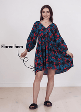 Woman wearing floral boho dress with V-neck and long lantern sleeves, sewing pattern 'Ivy', front view