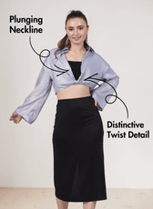 Front view of blue twist front crop shirt with long bell sleeves and distinctive twist detail