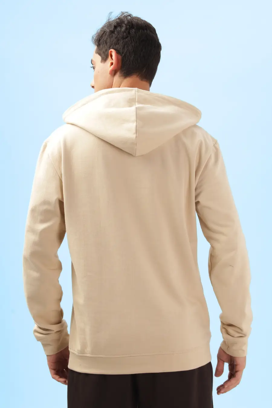 Back view of a beige men's hoodie from the 'Atlas' sewing pattern. Features a relaxed fit with a hood and ribbed hem for a comfortable wear.