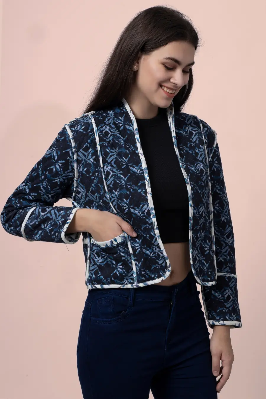 Side view of the Romy reversible quilted jacket in a dark blue geometric pattern. Features contrast binding and a functional pocket for added style.