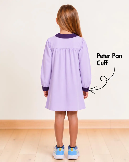 Back view of girl in purple night gown with Peter Pan collar and cuffs, long sleeves, button-up front, knee-length, indoor setting