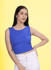 Close up front view of a model wearing a blue ruched top sewn with Winslet's pattern, showcasing a flattering fit and chic style. Paired with trousers