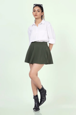 a woman in a white shirt and green mini skater skirt sewed with winslets patterns