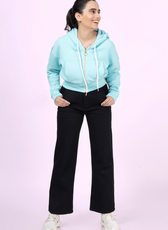 Model wearing the 'Rue' zip-up hoodie in light blue. A casual and sporty cropped hoodie with a front pocket, ribbed waistband, and adjustable hood.