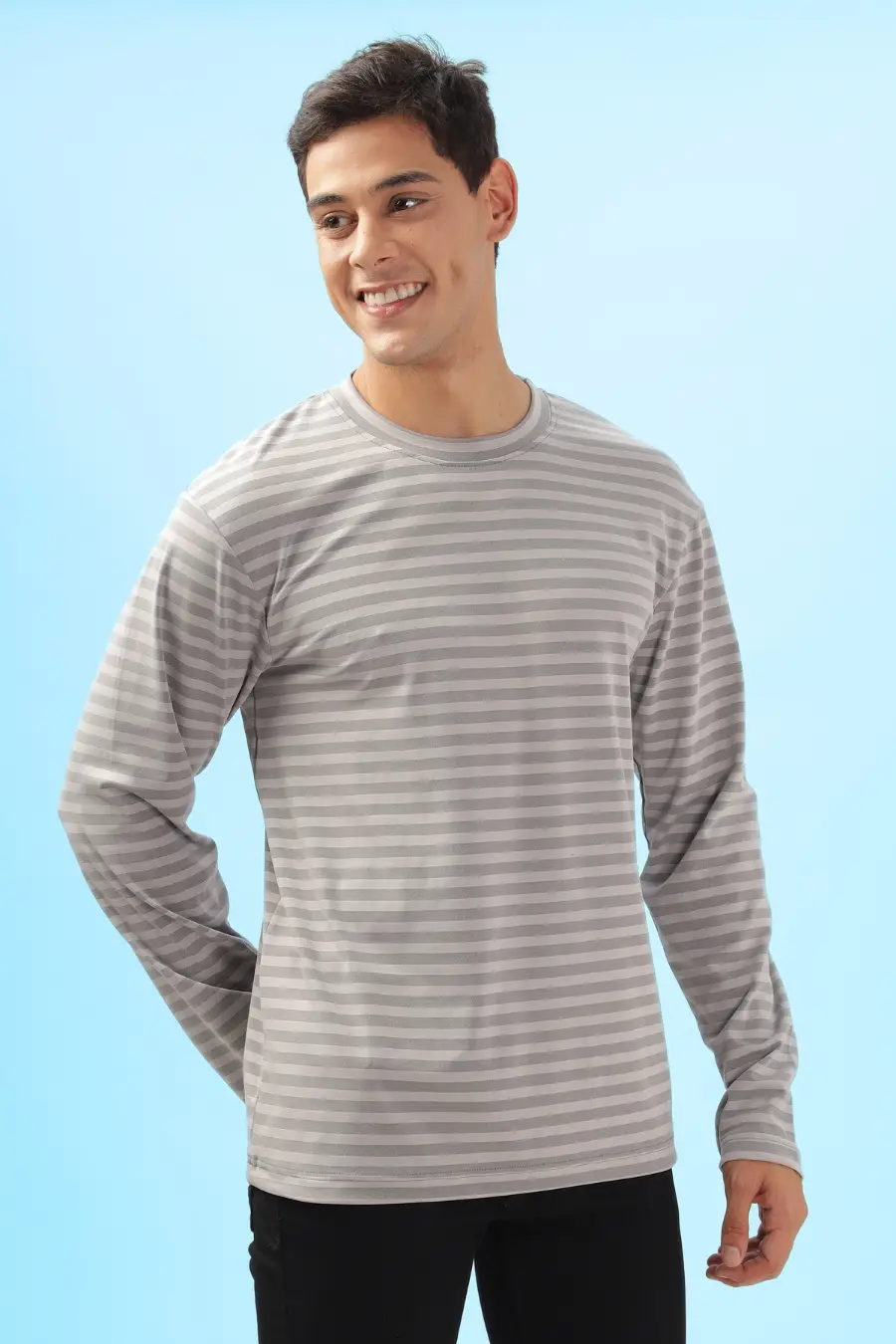 Smiling model wearing a striped men's long sleeve T-shirt sewn using the 'Maddy' pattern. Comfortable fit with a straight hem and full-length sleeves.