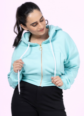 Close-up of the 'Rue' zip-up hoodie sewing pattern. Features a cropped fit, front pocket, ribbed cuffs, and a stylish gold zipper for a modern look.