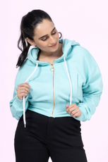 Close-up of the 'Rue' zip-up hoodie sewing pattern. Features a cropped fit, front pocket, ribbed cuffs, and a stylish gold zipper for a modern look.