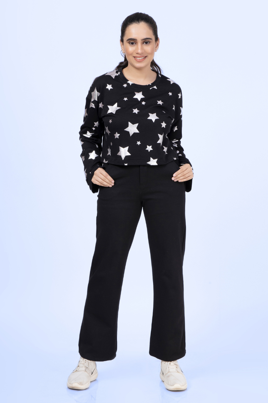 Front view of the Selena sweatshirt in black with silver stars, styled with black pants for a casual yet stylish look.