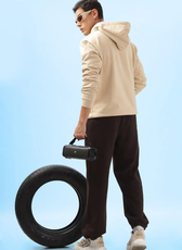 Rear view of a model wearing the 'Atlas' men's hoodie. Displays the hood and relaxed fit, paired with dark pants and casual sneakers.