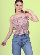 Woman wearing a strappy ruffle top with blue jeans