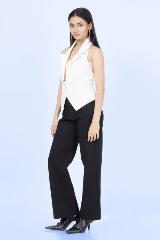 Side view of a model wearing a white halter neck vest with a sharp collar and tailored fit. The vest cinches at the waist, creating a flattering silhouette.