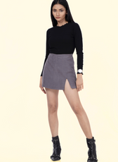 Model wearing the 'Jasmine' skort, a stylish mini skort with an asymmetrical front flap. Perfect for active wear with a chic and modern design.