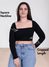 Woman wearing black square neck crop top with long sleeves and high-waisted jeans