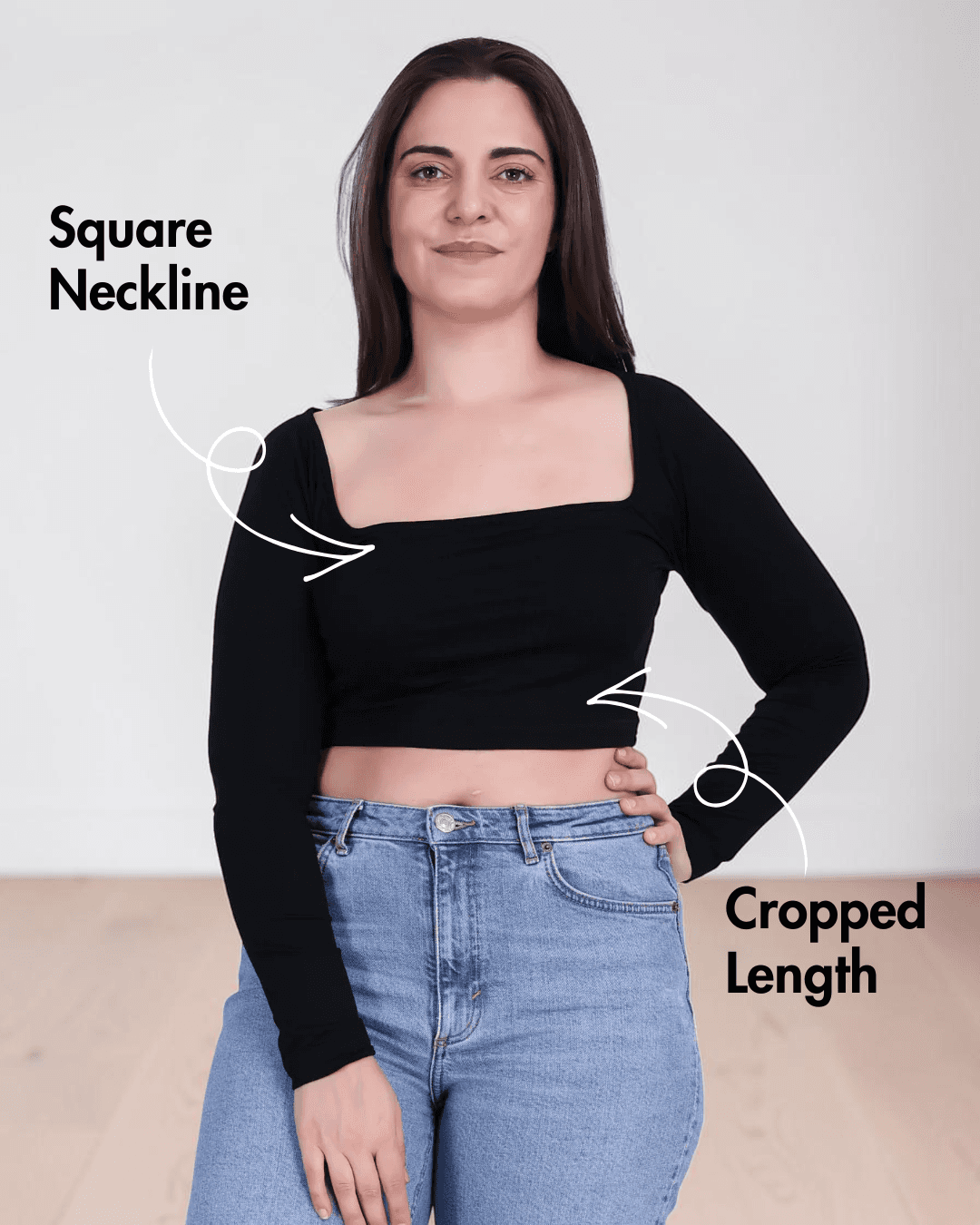 Woman wearing black square neck crop top with long sleeves and high-waisted jeans